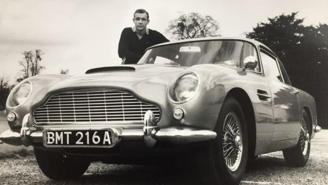 Sean Connery as James Bond in the 1964 movie next to his iconic DB5 car
