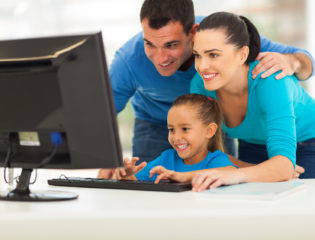 happy family using computer together at home