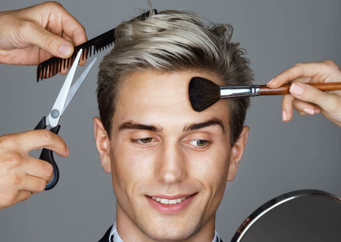 A young man being groomed with a range of grooming accessories